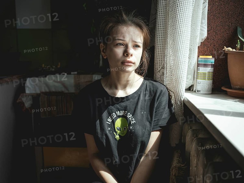 Alina, 15 years old, in the kitchen of the flat where she lives with her siblings, her mother and her stepfather. Ukrainsk is very close to the front line, the building next door was destroyed hours ago and a woman died. The stepfather, severely marked by drug abuse, refuses to leave the flat and the city, Ukrainsk, Ukraine