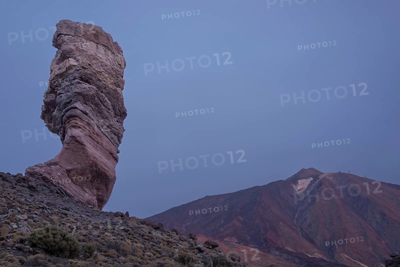 Panorama in front of sunrise of the Roque Chinchado, also known as the Stone Tree or Finger of God, landmark of the island, Los Roques de Garcia, behind it the Pico del Teide, 3717m, Las Cañadas, Teide National Park, Tenerife, Canary Islands, Spain