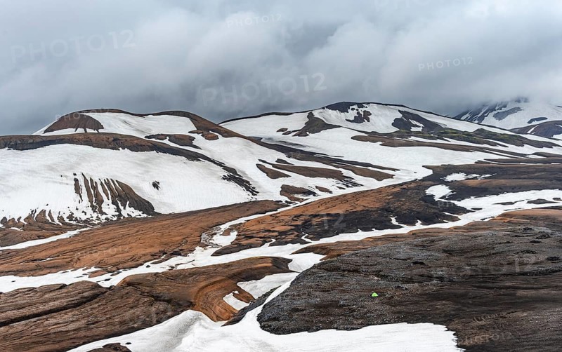Dramatic volcanic landscape with mountains and snow, at Höskuldsskáli hut in Hrafntinnusker, Laugavegur trekking trail, Landmannalaugar, Fjallabak Nature Reserve, Suðurland, Iceland