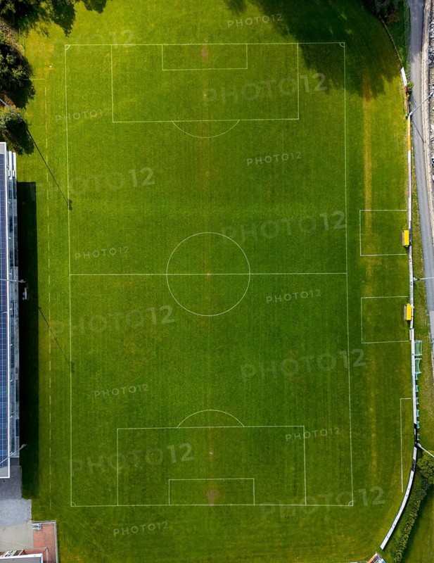 Aerial view of a football field in Brig, showcasing vibrant green grass and clear field markings under sunlight. Perfect for sports, recreation, and landscape imagery
