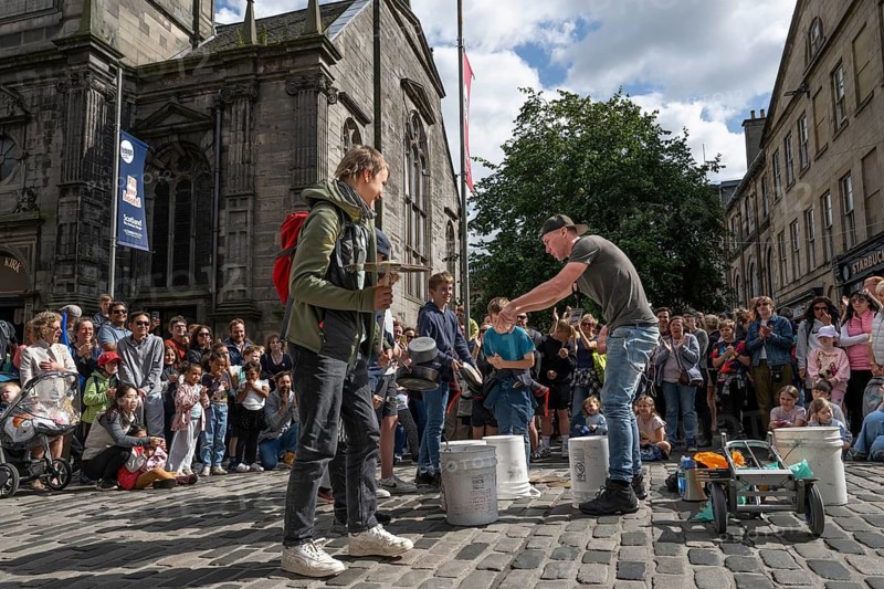 Street musician surrounded by spectators drumming on empty buckets, world's largest cultural festival The Fringe, High Street, Edinburgh, Scotland, United Kingdom, United Kingdom