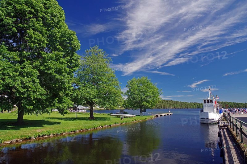 River landscape with boats and tall trees under a clear sky, Haverud, Dalsland Canal, Dalsland, Sweden