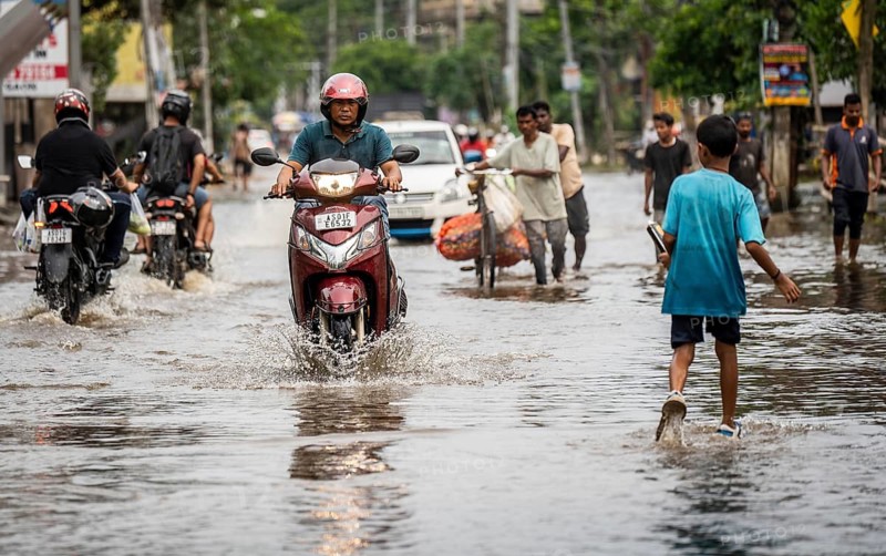 Commuters passing through a waterlogged street following heavy rainfall in Guwahati, India, on 1 June 2025