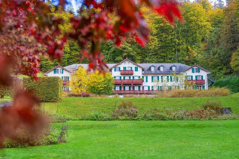 Large country house in green surroundings, surrounded by autumnal trees and shrubs, Grandhotel Giessbach, Lake Brienz, Switzerland