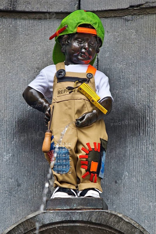 Bronze statue Manneken Pis by Jérôme Duquesnoy, fountain figure of a urinating boy in costume, landmark, Brussels, Belgium
