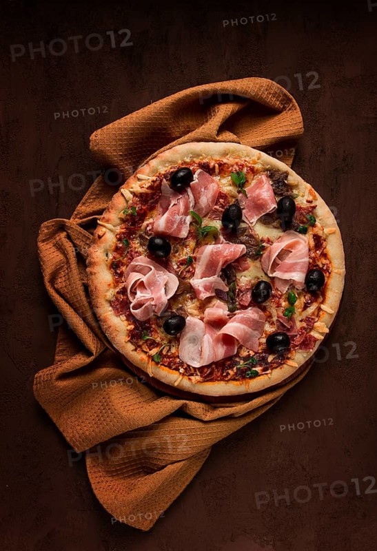 Pizza with prosciutto and mushrooms, bacon, olives, homemade, top view, no people