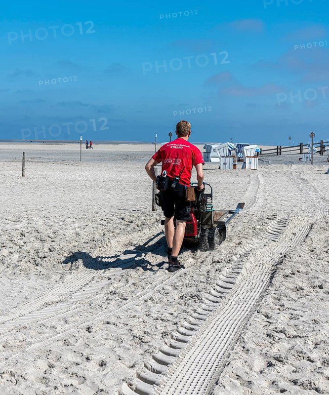 Worker with cleaning machine on the sandy beach of the North Sea, Sankt Peter-Ording, Schleswig-Holstein, Germany