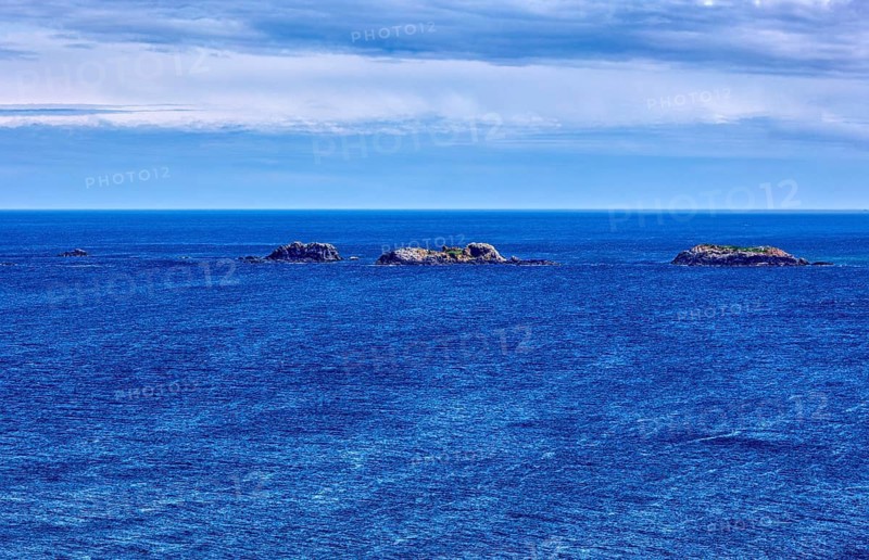 Calm of the deep blue sea with several small islands on the horizon, Malin Head