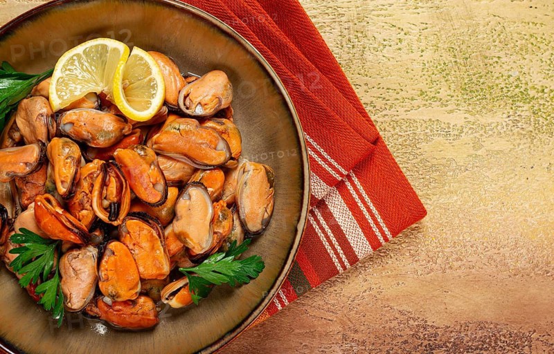 Mussels no shell, boiled, mussels, peeled, in a bowl, with lemon and parsley, Chilean mussels, top view, no people