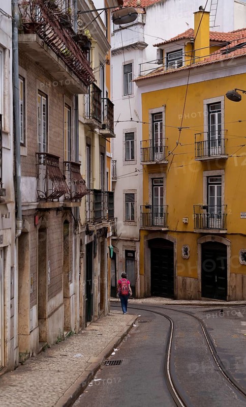Woman with rucksack, tram tracks, Old Town, Lisbon, Portugal