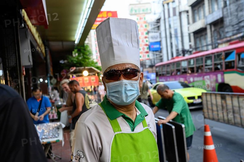 Bangkok, Thailand. February 18th 2025. A local chef wearing sunglasses a face mask and chef's hat, Yaowarat Road, Chinatown, Bangkok, Thailand