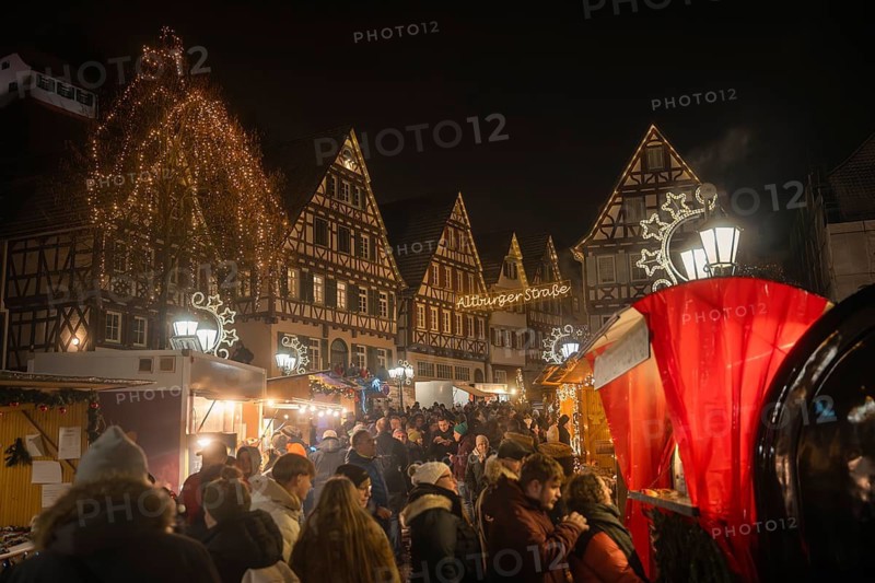 Dense crowds at a Christmas market in a festively illuminated old town, Christmas market Calw, Black Forest, Germany