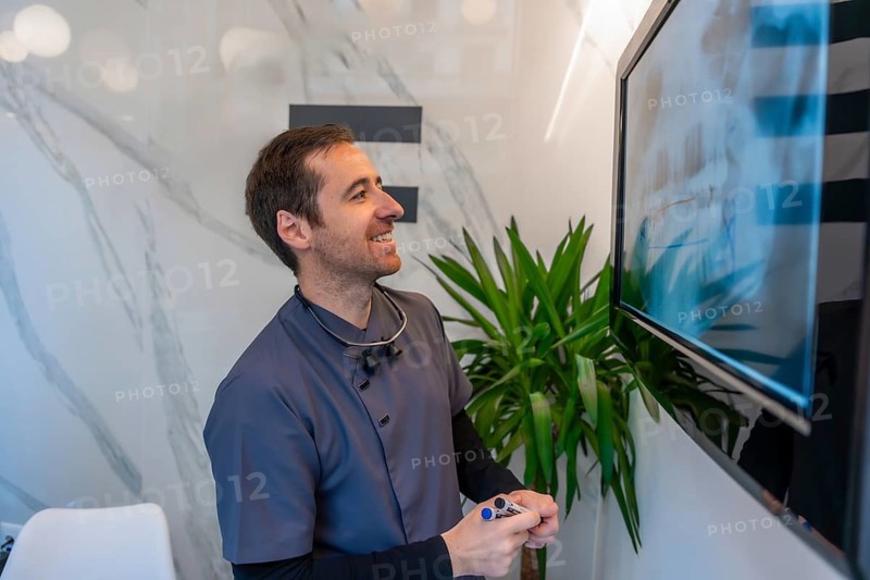 Dentist analyzing a dental x ray image on a monitor, demonstrating expertise in oral healthcare within a contemporary clinic setting