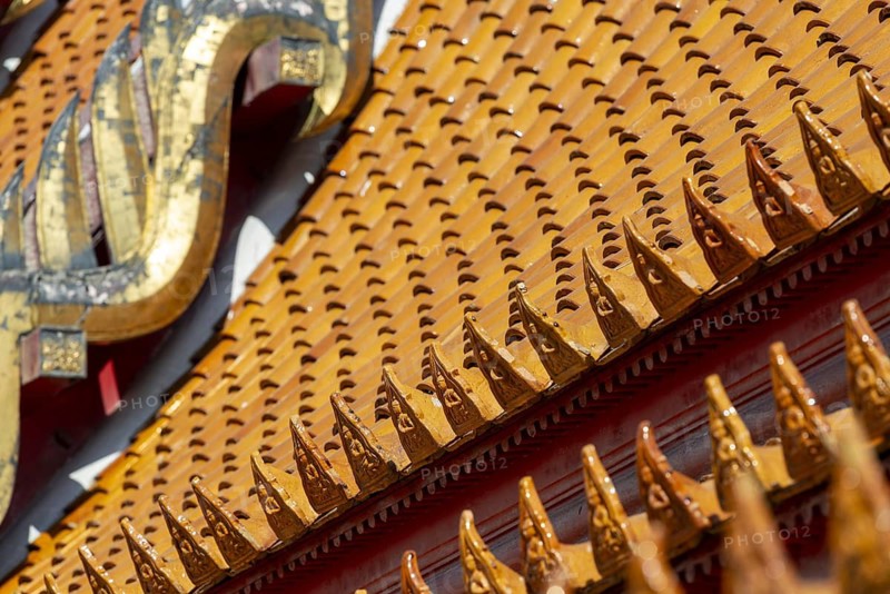 Roof decoration at the Uposatha Hall, Ubosot, the roof is staggered in three tiers and covered with rows of golden yellow glazed Chinese tiles, the last tile of each row at the eaves represents a heavenly angel offering the traditional Thai obeisance Wai to the viewer with folded hands, Wat Benchamabophit, marble temple, Bangkok, Thailand