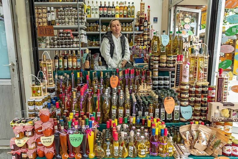 Stall with liqueurs, schnapps, honey and olive oil at the market in Trogir, Croatia