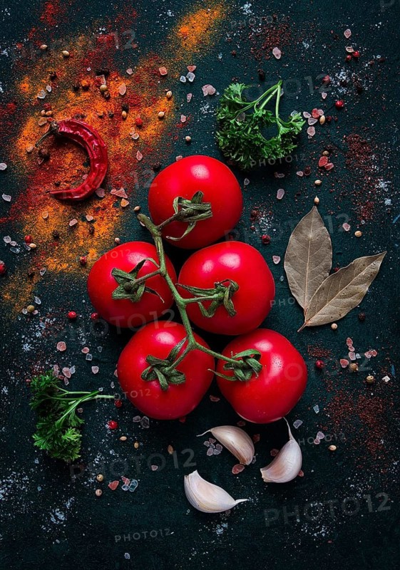 Tomato branch, on dark green background, with spices, top view, food background, vertical, no people