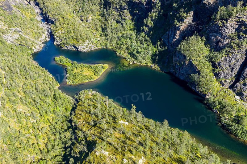 Aerial view of an island in a turquoise colored river surrounded by birch forest, valley Aurlandsdalen, Norway