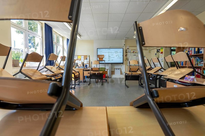 Classroom of a fourth grade, after school, the building is older but in good condition, modern teaching materials, interactive, digital whiteboard