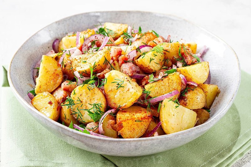 German potato salad, with bacon, onion and herbs, served in a bowl, homemade, no people