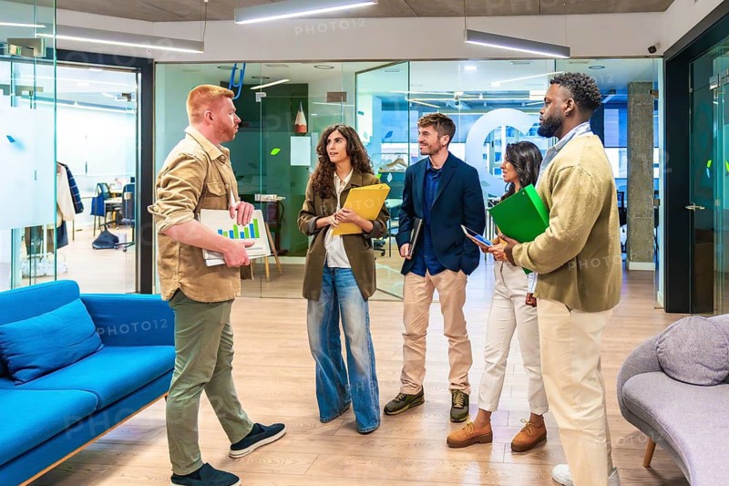 Diverse professionals collaborating and discussing business strategies in a modern office, promoting innovation and teamwork