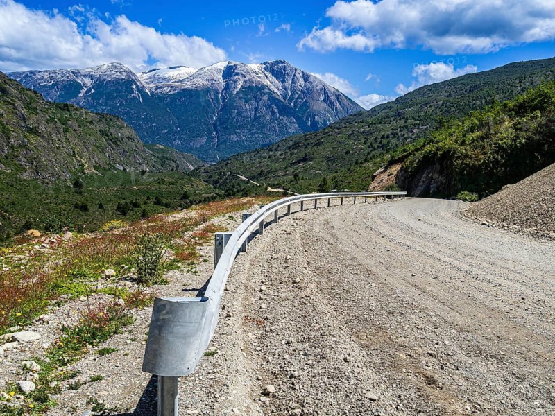 Winding road, pass on the Carretera Austral south of Cochrane, gravel surface, mountain range in background, Patagonia, Chile