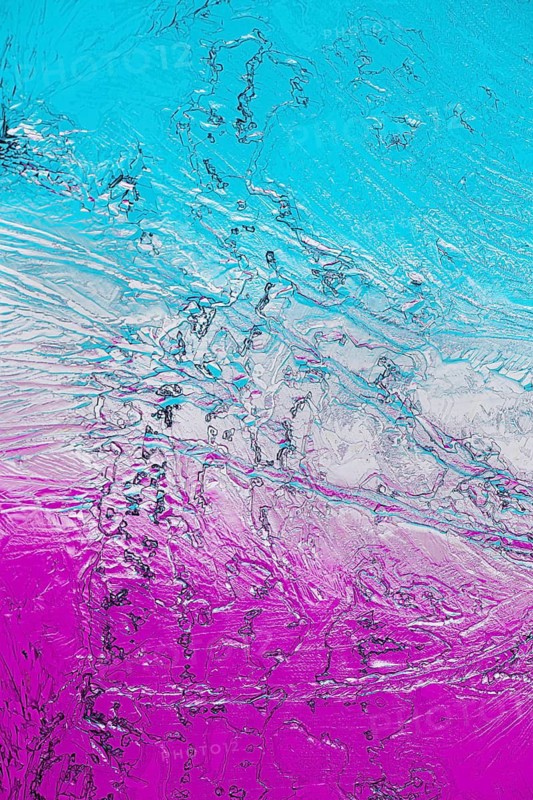 A vibrant close-up of microcrystals viewed under a microscope, featuring bright shades of turquoise and pink. The intricate details and textures highlight the stunning natural patterns formed by crystallization