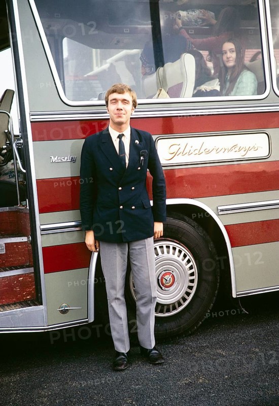 Full body portrait of a male coach driver standing next to his coach, Gliderways Coaches of Smethwick, West Midlands, England, UK 1972