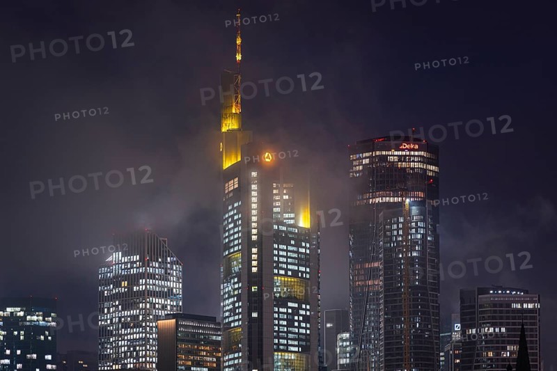 Low clouds envelop the shining towers of Frankfurt's banking skyline in the evening. Frankfurt am Main, Hesse, Germany