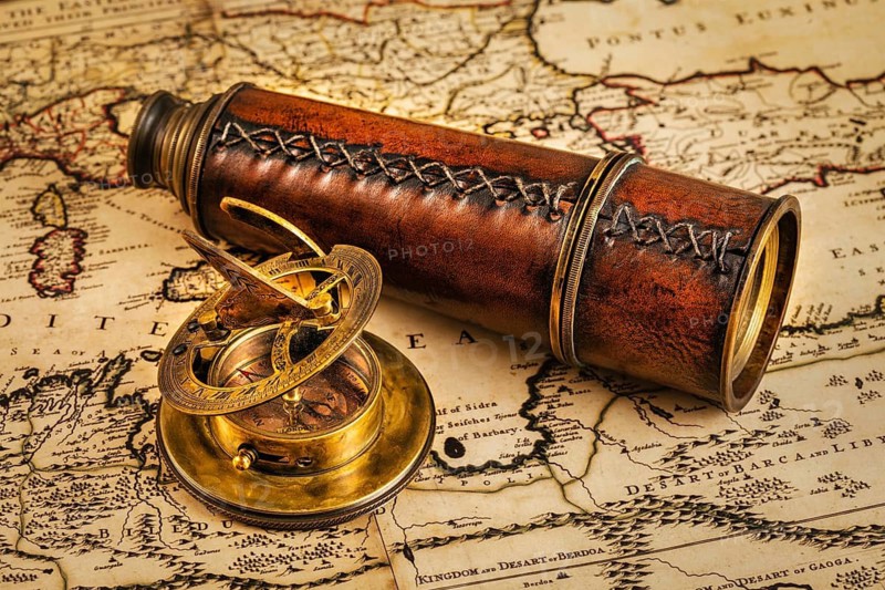 Travel geography navigation concept background, old vintage retro compass with sundial and spyglass on ancient world map
