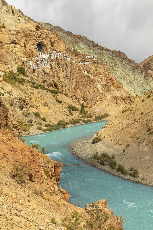 Phugtal Monastery, perched on a cliff in the Lungnak Valley, Ladakh, offers a breathtaking view of the turquoise river below. A serene retreat in the Himalayan landscape