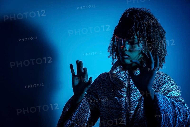 Woman wearing ar headset interacting with virtual reality using hand gestures, illuminated by blue light, futuristic technology concept
