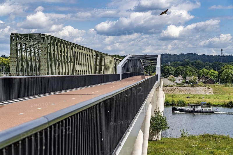 De Massover cycle path bridge, over the Meuse south of Nijmegen, near Cuijk, part of the MaasWaalpad long-distance cycle path, 12 km between Nijmegen and Cuijk, built in 2021, for 15 million euros, Meuse river crossing for cyclists and pedestrians, part of a cycle path network, used by many commuters, next to a railway bridge, Netherlands