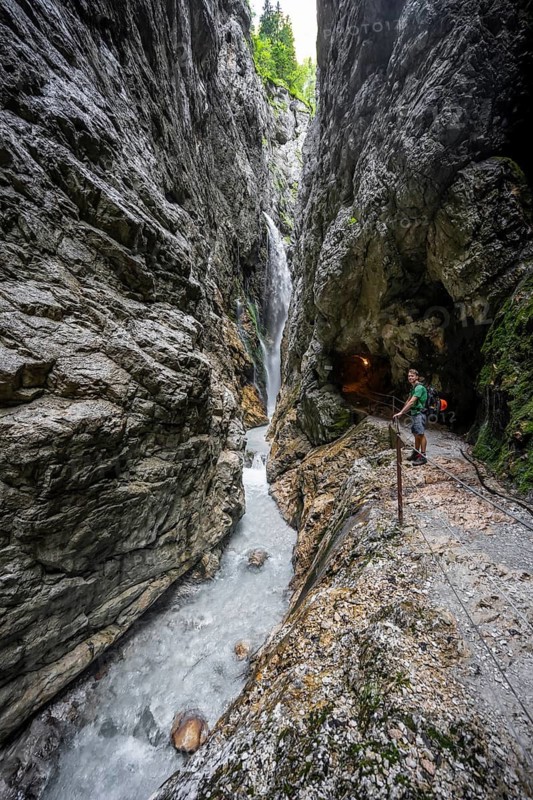 Waterfall and mountain stream Hammersbach in a canyon, mountaineers on a hiking trail in a gorge, Höllentalklamm, Höllental, Bavaria, Germany