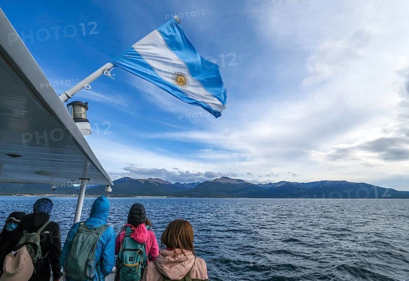Ushuaia, Tierra del Fuego, Argentina, tourists on an excursion boat flying the Argentinian flag in the Beagle Channel