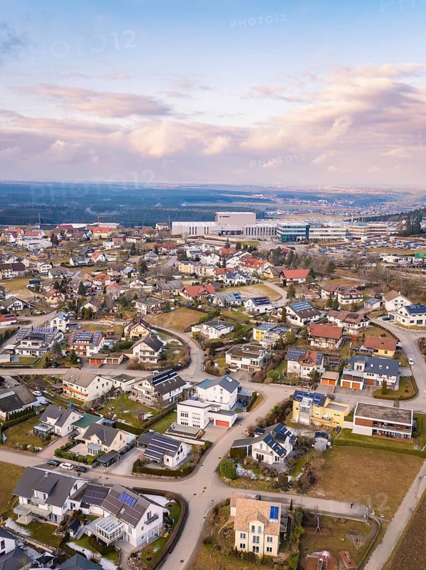 Aerial view of a sprawling suburban neighbourhood with many houses and streets under a cloudy sky, Schopfloch, Freudenstadt district, Germany