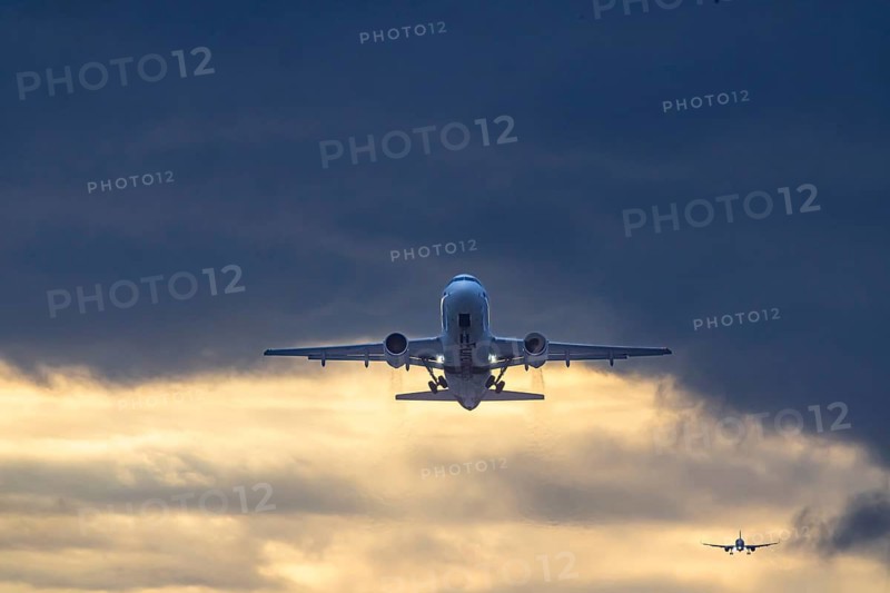 Stuttgart airport with Eurwings aircraft taking off. Behind it, an airplane landing in front of dark clouds. Stuttgart, Baden-Württemberg, Germany