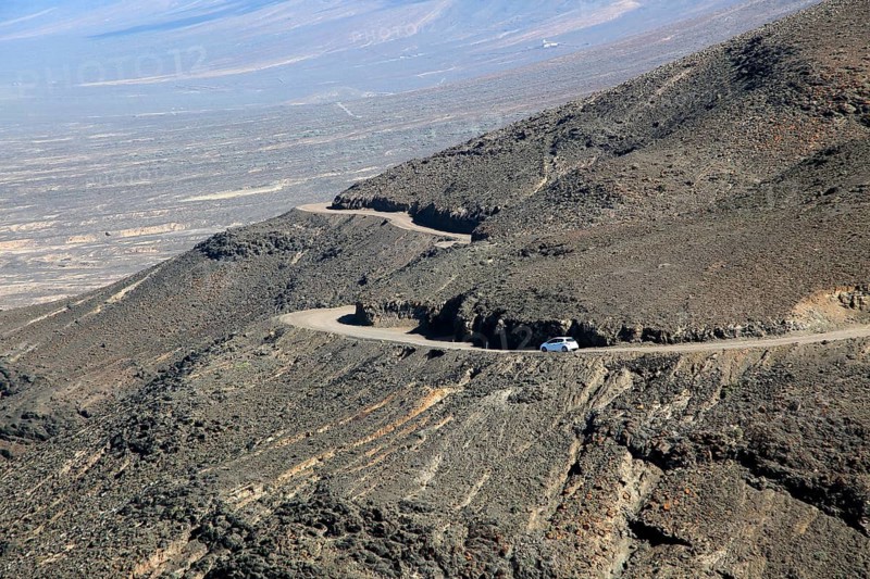 Car driving on unsurfaced road, Atlantic Ocean coast, Jandia peninsula, Fuerteventura, Canary Islands, Spain