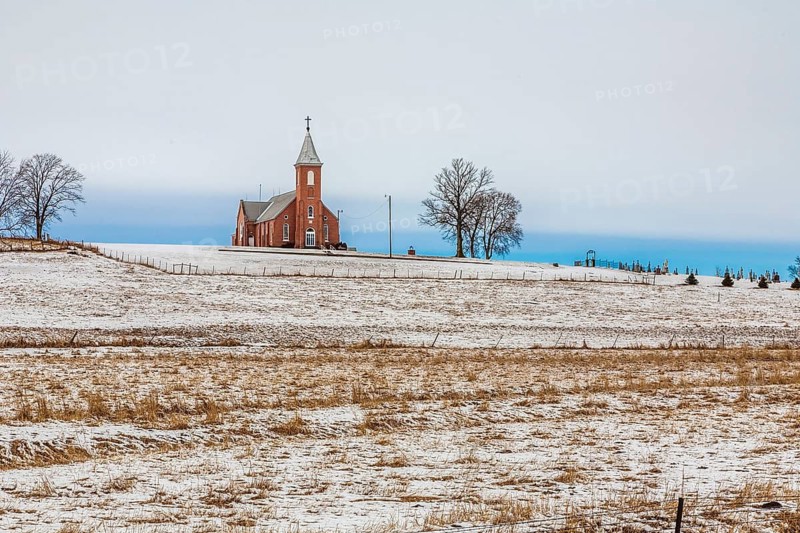 Church and cemetery on a hill surrounded by grain fields in rural north east Nebraska, USA