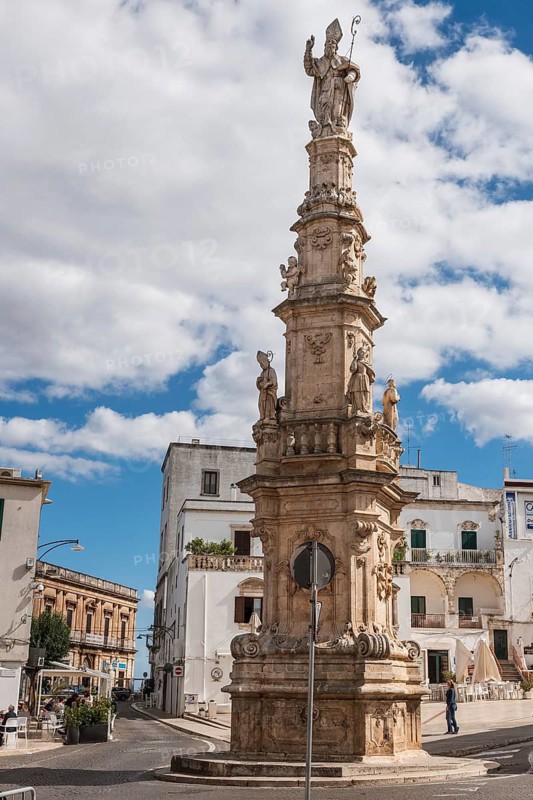 OSTUNI, ITALY - SEPTEMBER 26, 2018: Statue of St Oronzo on a column in the central square (Piazza Sant'Oronzo). The town is renowned for its whitewashed houses