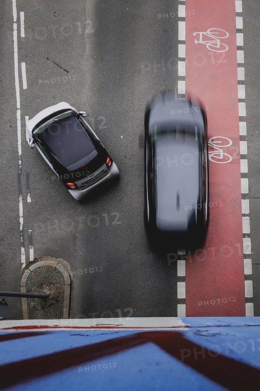 A car overtakes a left-turning cyclist on the marked cycle path in Berlin, 27/02/2024