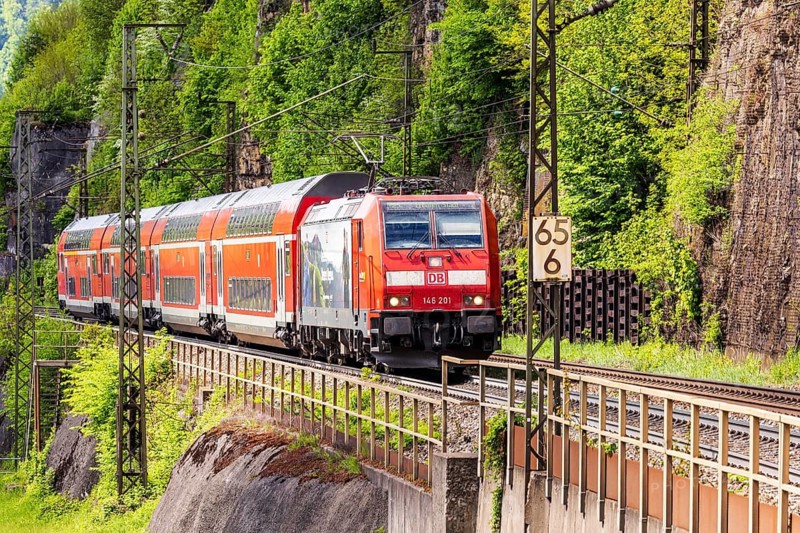 Regional express RE5 en route on the winding railway line of the Geislinger Steige. Landscape along the railway line in spring. Amstetten, Baden-Württemberg, Germany