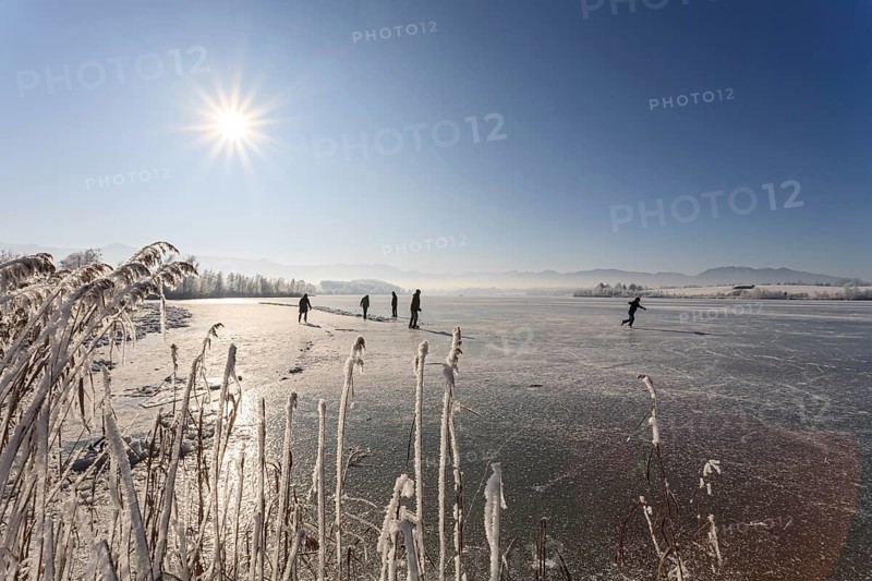 People on an icy lake, ice skating, sunny, Riegsee, Alpine foothills, Upper Bavaria, Bavaria, Germany