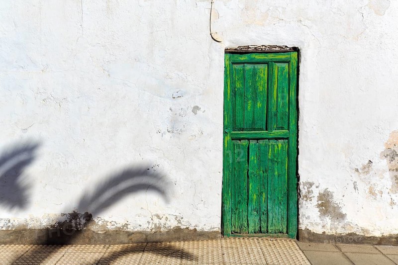 Green painted wooden door, white facade, peeling paint, facade detail, Haria, Lanzarote, Canary Islands, Spain