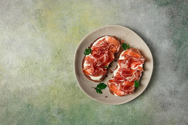 Sandwich with cream cheese and prosciutto, on black grain bread, breakfast, homemade