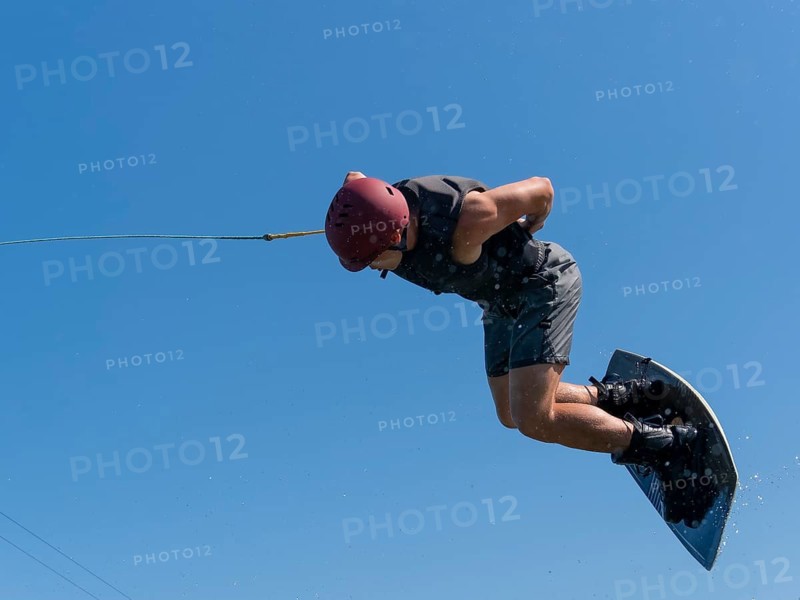 Man does a somersault with wakeboard, water ski and wakepark