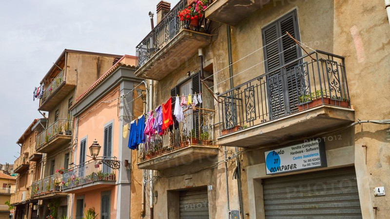 Row of houses, balconies, laundry on line, Randazzo, town, Nebrodi National Park, Sicily, Italy
