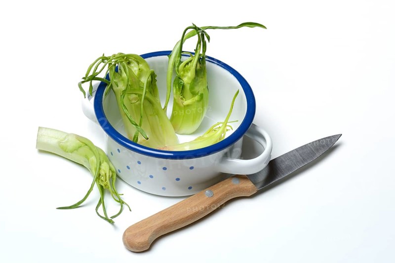 Puntarelle in bowl with knife, asparagus chicory
