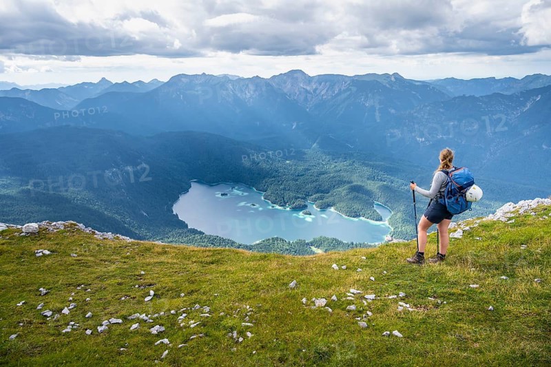 Hiker in the mountains, view of Eibsee lake and Werdenfelser Land, Wetterstein Mountains, Garmisch-Patenkirchen, Bavaria, Germany