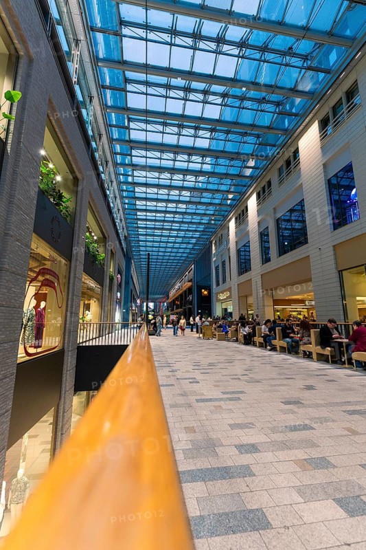 A busy shopping centre with a glass roof and people strolling through the aisles, Berlin, Germany