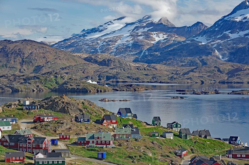 A colorful village with snow-capped mountains and calm water, Tasilaq, Arctic, Greenland, Denmark